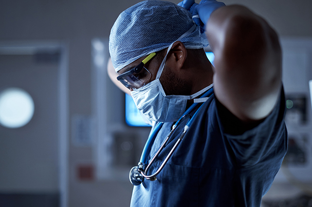 a surgeon ties his mask