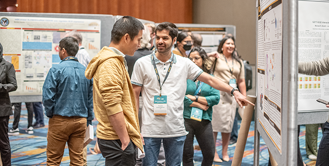 Massey researchers discussing a scientific poster at a research event.