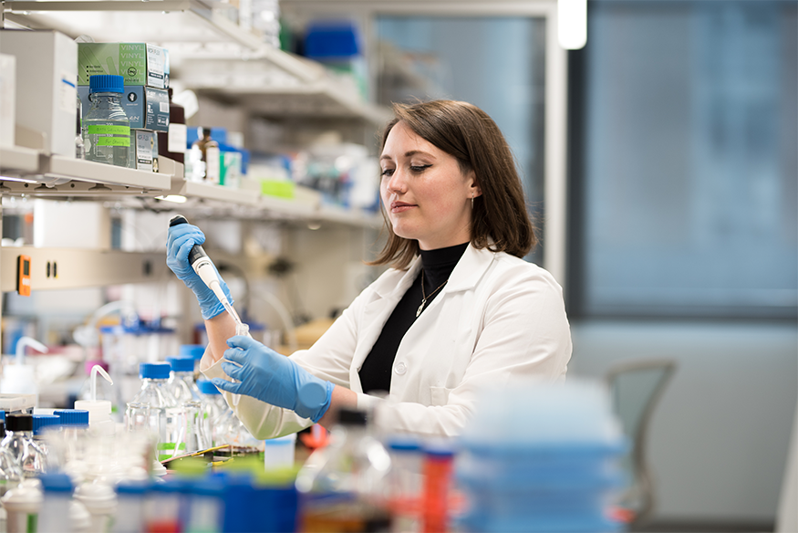 A female researcher conducts an experiment using a pipette in a Massey laboratory