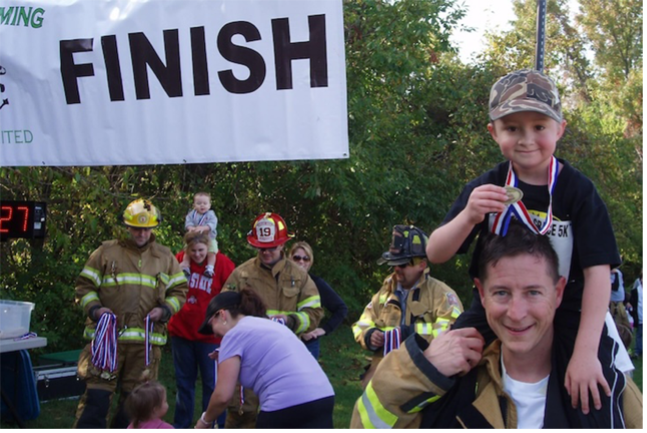 Leitz volunteering at a event with a kid on his shoulders